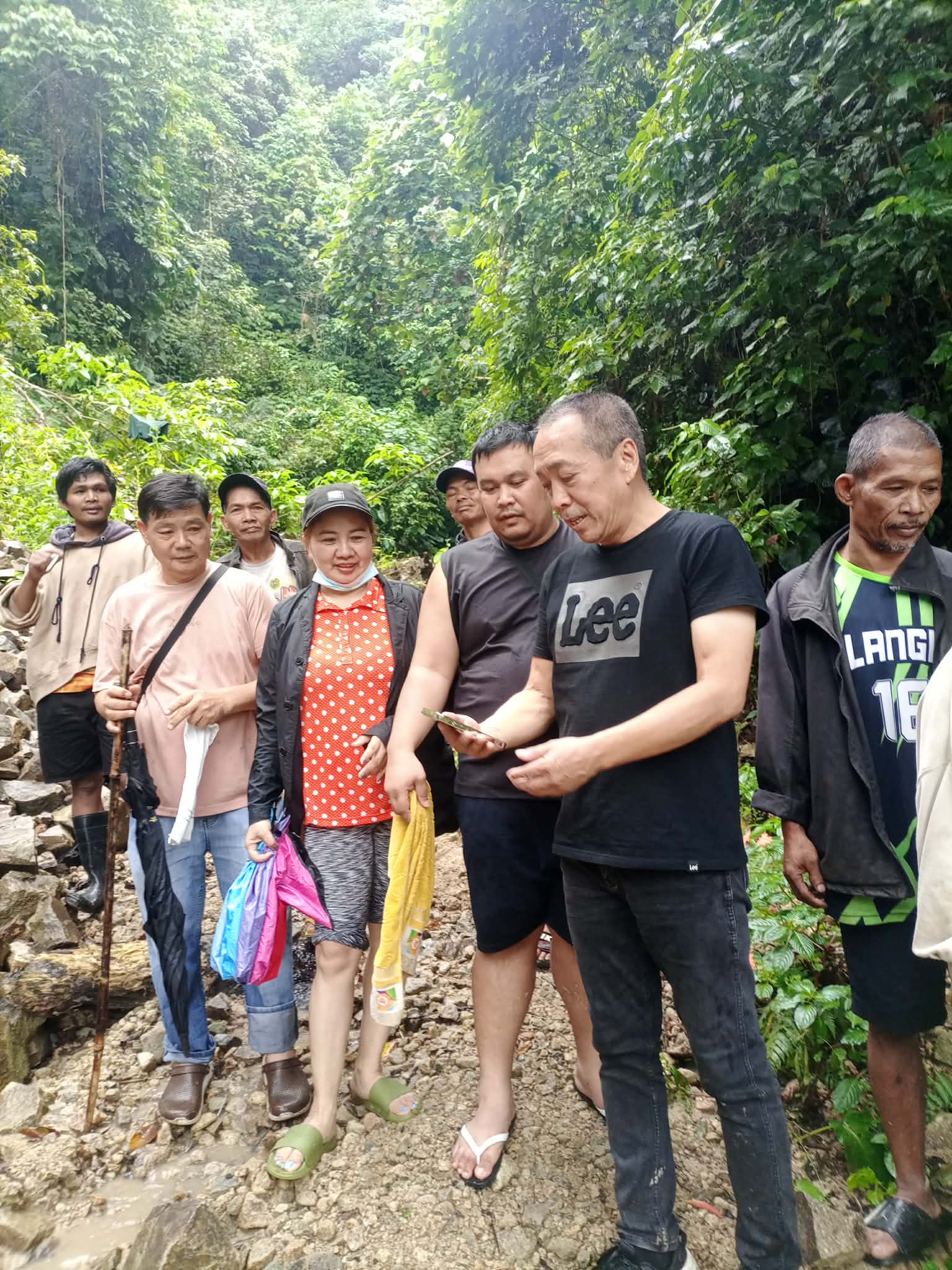 Camotto representatives standing with local miners at a forested field site