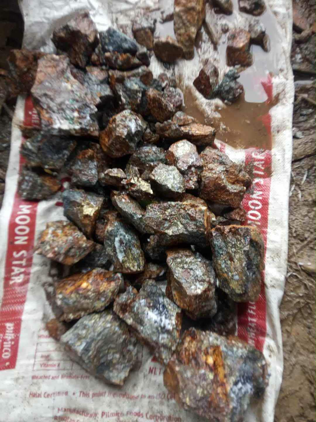 Rough mineral pieces arranged on a sack for visual review