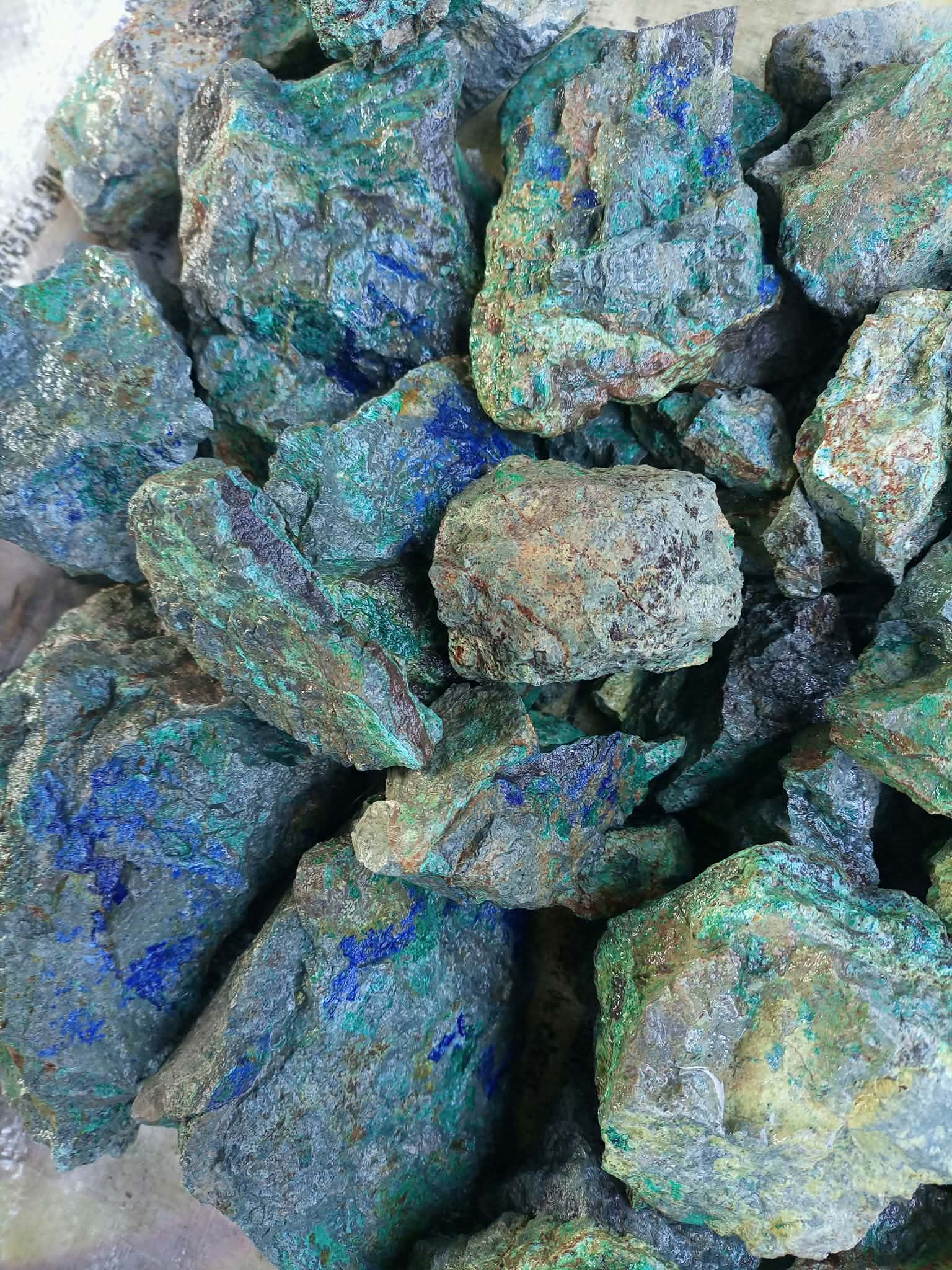 Blue-green mineral-bearing rocks photographed together